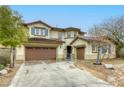Beautiful two-story home featuring a three car garage and desert landscaping at 9160 Moose Country Pl, Las Vegas, NV 89178