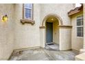 Inviting front entry with an arched entryway and textured stucco walls at 9160 Moose Country Pl, Las Vegas, NV 89178