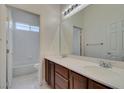 Bright bathroom with double sinks, a large mirror, and a separate tub/shower at 10260 Hawks Wing St, Las Vegas, NV 89178
