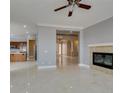 Spacious living room with marble floors, fireplace, and an open floor plan flowing into the kitchen at 10260 Hawks Wing St, Las Vegas, NV 89178