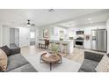 Bright open living space with modern kitchen, white cabinets, stainless steel appliances, and breakfast bar at 105 Ash St, Henderson, NV 89015