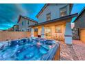 Backyard features a rejuvenating hot tub and covered patio, perfect for relaxation at 122 Cabaletta Ln, Henderson, NV 89015