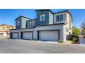 View of new construction townhomes showcasing private garages and modern landscaping at 12728 Feathersong St, Henderson, NV 89044
