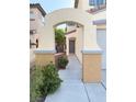 Inviting walkway leads to the front door, framed by an elegant archway and lush landscaping at 2431 Lilac Cove St, Las Vegas, NV 89135