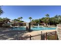 Community pool area featuring a large pool, water slide, and covered seating under a clear blue sky at 2431 Lilac Cove St, Las Vegas, NV 89135