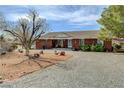 Brick ranch-style home with desert landscaping, comfortable seating and gravel driveway at 3140 Unicorn Ave, Pahrump, NV 89048