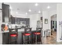 Modern kitchen features granite countertops, dark cabinetry, stainless steel appliances, and an island with seating at 3632 Julia Waldene Ct, Las Vegas, NV 89129