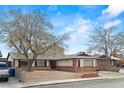 Charming single-story home with brick accents, mature trees and a driveway at 4155 Comb Cir, Las Vegas, NV 89104