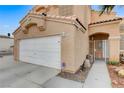 Close up of home's facade showing two car garage, front door and desert landscaping at 4431 Palm Mesa Dr, Las Vegas, NV 89120