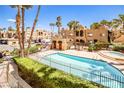 Community pool and hot tub with lush green landscaping and multiple buildings in the background at 5121 Pioneer Ave # 204, Las Vegas, NV 89146