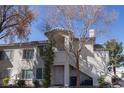 Charming two-story exterior with a private entrance, balcony, and mature trees at 5206 Mandalay Springs Dr # 204, Las Vegas, NV 89120