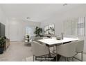 Virtually staged living and dining area boasting neutral tones and bright natural light at 5240 Adorato Dr, North Las Vegas, NV 89031