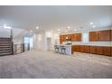 Spacious open floor plan featuring carpeted living area, stairs, and a kitchen with an island at 5748 Avondale Rise Way, Las Vegas, NV 89141