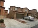 Two-story home with a two-car garage and front yard, showcasing its architectural design and curb appeal at 668 Moonlight Stroll St, Henderson, NV 89002