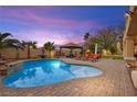 Sparkling swimming pool with lush landscaping and a cozy cabana for relaxation at 9011 Tierra Santa Ave, Las Vegas, NV 89129