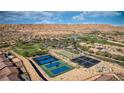 Panoramic aerial view showcasing community tennis courts, lush landscaping, and the desert's natural beauty at 906 Majestic Vw, Mesquite, NV 89034
