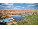 Expansive view featuring a community pool, lake, and golf course set against a desert landscape and mountain backdrop at 906 Majestic Vw, Mesquite, NV 89034