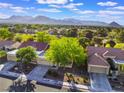 Scenic aerial view of a suburban neighborhood with lush green trees and a backdrop of majestic mountains at 2553 Showcase Dr, Las Vegas, NV 89134