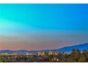 Expansive views of the city skyline and surrounding mountains at dusk at 3002 Hickory Valley Rd, Henderson, NV 89052