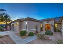 Side view of a well-maintained home featuring manicured landscaping, a two-car garage and covered entry at 3002 Hickory Valley Rd, Henderson, NV 89052