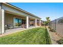 Well-maintained backyard featuring lush grass, covered patio, and a fenced perimeter at 4772 Se Argent Hills Ave, Pahrump, NV 89061