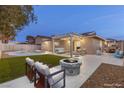 Inviting backyard with a pool, fire pit, and outdoor living space with covered patio, perfect for entertaining at 4842 Plata Del Sol Dr, Las Vegas, NV 89121