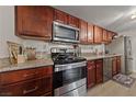 Well-equipped kitchen with stainless steel appliances, granite counters, and ample cherry wood cabinetry at 5180 Indian River Dr # 355, Las Vegas, NV 89103