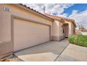 Close up exterior view of the 2 car garage and covered front entryway with well maintained landscaping at 576 Bayo Canyon Ct, Henderson, NV 89015