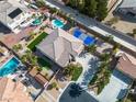 Expansive aerial view of property showcasing the backyard pool, sports court, manicured landscaping, and tile roof at 6214 Ebony Legends Ave, Las Vegas, NV 89131
