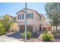 Two-story home with neutral stucco, two-car garage, and tidy desert landscaping for low-maintenance curb appeal at 6487 W Levi Ave, Las Vegas, NV 89141