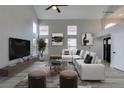 Contemporary living room featuring high ceilings, a large sectional sofa, and ample natural light at 71 Sea Holly Way, Henderson, NV 89074