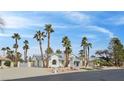 Inviting single-story home with lush palm trees and meticulous desert landscaping at 8112 Golfers Oasis Dr, Las Vegas, NV 89149