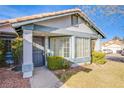 Inviting front porch with a decorative storm door, manicured bushes, and manicured lawn at 819 Teal Wing Way, Henderson, NV 89002