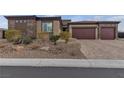 Paver driveway leading to a three-car garage, surrounded by desert landscaping at 9035 Chiffon Mist Ave, Las Vegas, NV 89129