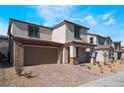 Attractive two-story residence showcasing a brick driveway, a two-car garage, and desert landscaping at 9333 Observatory St, Las Vegas, NV 89143