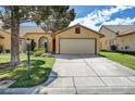 A tan house with a large garage, a well-maintained lawn, and mature landscaping at , Las Vegas, NV 89130