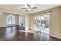 Bright living room with hardwood floors, ceiling fan, fireplace, and access to the backyard at 10199 Rising Tree St, Las Vegas, NV 89183