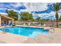 Community pool offers a refreshing escape with lounge chairs and well-maintained surroundings at 10199 Rising Tree St, Las Vegas, NV 89183