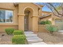 Stucco home with arched entryway, concrete steps, and well-maintained front yard at 12277 Bluebird Canyon Pl, Las Vegas, NV 89138