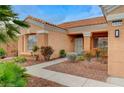 Charming home entrance with desert landscaping, a paved walkway, and a covered porch at 1925 Hot Oak Ridge St, Las Vegas, NV 89134