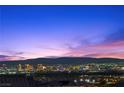Distant city view and mountains in the evening over rooftops from elevated backyard at 294 Besame Ct, Las Vegas, NV 89138