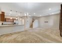 Spacious living area with neutral tones, carpet floors, staircase and open to the kitchen at 3165 Brynley Ave, Henderson, NV 89044