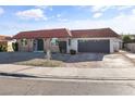 Single-story home featuring red tile roof, arched windows, front yard desert landscaping, and a gray attached garage at 3672 Madrid St, Las Vegas, NV 89121