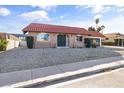 Single-story home showing desert front yard, brick facade, arched windows, and a striking red-tiled roof at 3672 Madrid St, Las Vegas, NV 89121
