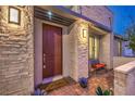 Inviting front door with covered entry, stone accents, and stylish outdoor lighting at 4273 Sunrise Flats St, Las Vegas, NV 89135