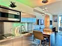 Compact, modern kitchen with stainless steel cabinets, appliances, and pendant lighting at 4381 W Flamingo Rd # 12304, Las Vegas, NV 89103