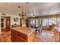 Bright kitchen and dining area with tile floors, central island and classic chandelier above the dining table at 4730 Mountain Valley Rd, Las Vegas, NV 89121