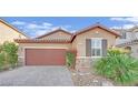 Charming home showcasing a two car garage, rock accents and desert landscaping at 5344 Bocopa St, Las Vegas, NV 89148