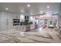 Modern kitchen featuring white cabinetry, stainless steel appliances, a marble countertop, and recessed lighting at 6655 Tranquil Seas Ct, Las Vegas, NV 89139