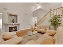 Bright living room with fireplace, hardwood floors, and staircase access at 8512 Porch Rocker St, Las Vegas, NV 89143
